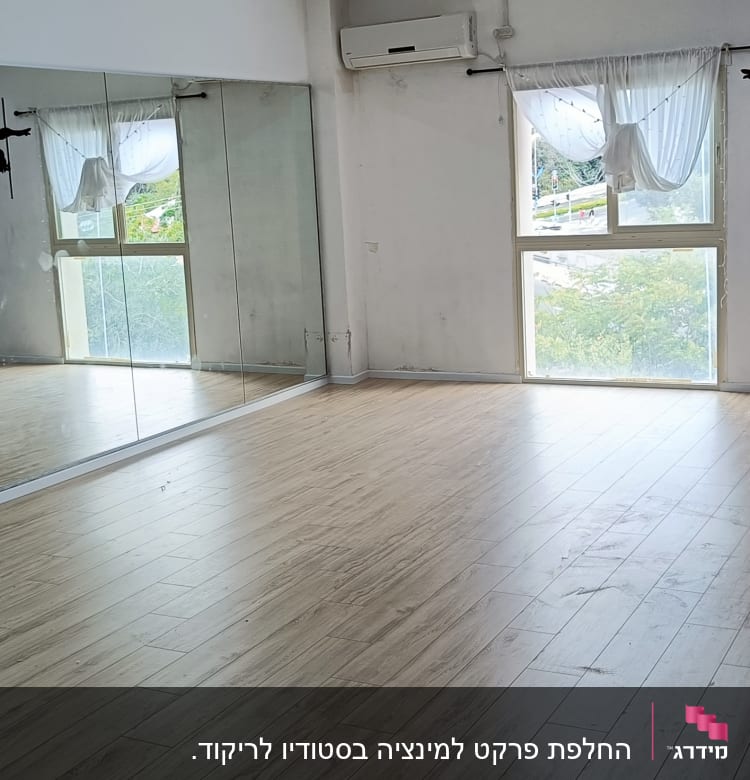 רצפת פרקט עץ בחדר סטודיו עם מראות